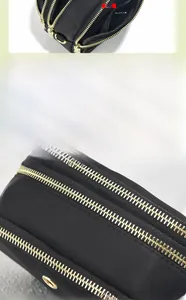 Dettaglio borsa a tracolla a tre strati in nylon nero con doppie cerniere dorate lucide