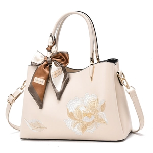 Ivory leather tote bag with floral embroidery and silk scarf handle decoration