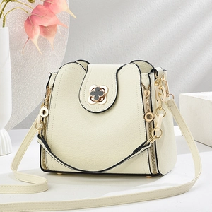 Creamy white bucket bag with gold clover lock and textured leather from a front view