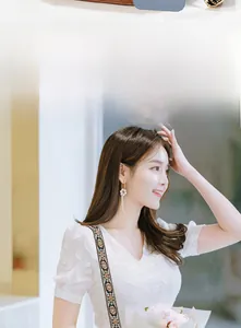 Side view of white flower earrings with long silver tassels on a fashion model