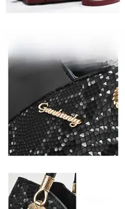 Close-up of black snake texture bag featuring gold hardware and shell-shaped metal accents