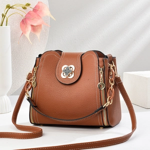Elegant brown pebble leather bucket bag with gold clover twist lock and chain strap