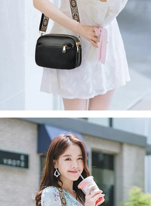Detail of black pebbled leather crossbody bag with three zippers and woven strap