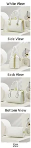 Detailed view of white quilted handbag with large pearl clasp and gold hardware