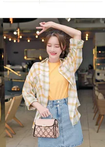 Fashionable pink monogram handbag styled with a yellow plaid shirt and denim skirt outfit