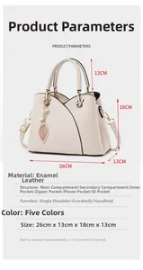 Detail view of cream lychee-textured leather handbag with gold leaf charm and pearl