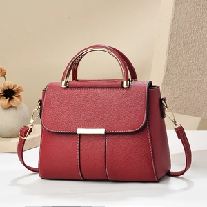 Sac à main en cuir grainé rouge foncé avec poignée anneau doré et coutures blanches