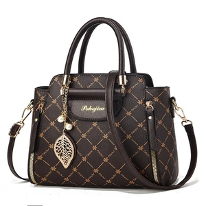 Sac à main en cuir marron avec motif monogramme floral et pendentif perle dorée