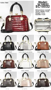 Close-up of crocodile embossed glossy shell bag featuring gold metal handle and rhinestone lock