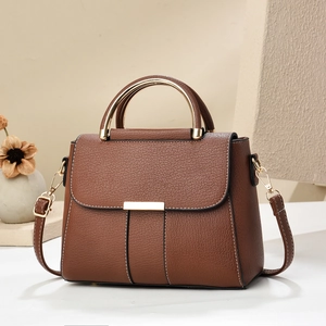 Détails d'un sac à main en cuir marron motif litchi avec poignée dorée et coutures fines
