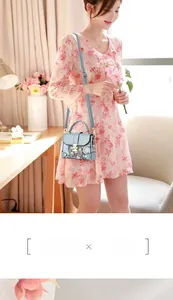 Close-up of light blue handbag with vintage floral patterns and metal buckle closure