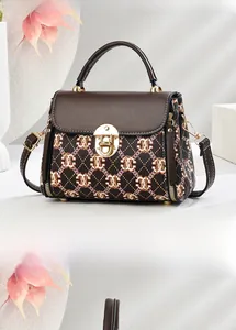 Detailed view of brown flap and black plaid PU leather crossbody bag with gold buckle