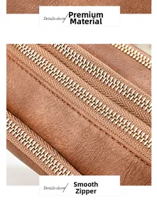 Detail view of smooth golden zippers on premium brown pebbled leather texture bag