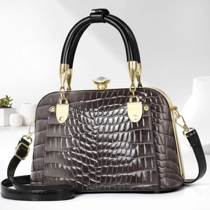 Detail of glossy crocodile pattern shell bag with crystal clasp and gold hardware
