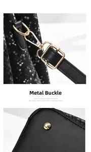 Detail of snake pattern leather stitching and gold hardware on large crossbody bag