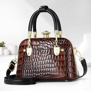 Detailed view of dark brown faux crocodile leather bag with crystal clasp and gold hardware