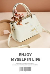 Detail of embroidered floral patterns on a premium cream faux leather handbag