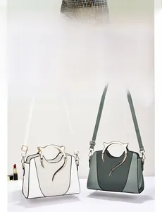 Detail of shell-shaped handbags with cat-ear metal handles and detachable shoulder straps