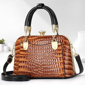 Detail of vintage brown crocodile texture handbag with gold clasp and black handle
