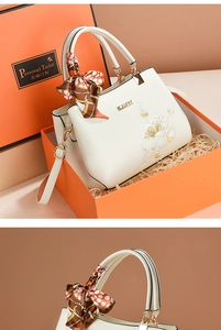 Detailed embroidery on white leather handbag with silk scarf and orange gift box