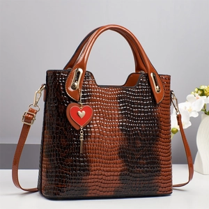 Brown faux crocodile leather bucket bag with red heart charm and gold hardware accents