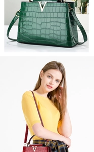 Dettaglio di borsa a mano coccodrillo con fibbia a V dorata e texture in pelle lucida