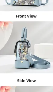 Detailed view of light blue handbag featuring floral paisley patterns and gold hardware