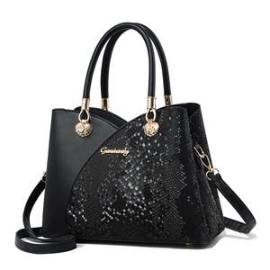 Women's black crossbody handbag with snakeskin pattern and elegant gold handles