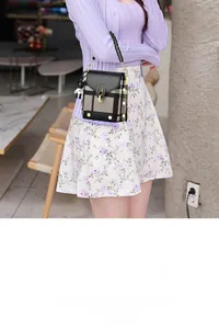 Détail du mini sac bandoulière à carreaux avec fermoir doré et pendentif panda mignon