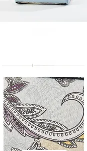 Detail showing the bottom metal feet and paisley patterned texture of the bag