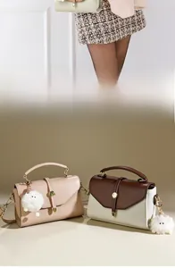 Detail von Leder-Umhängetaschen mit Metalldrehverschluss und weichem Fellbommel-Anhänger