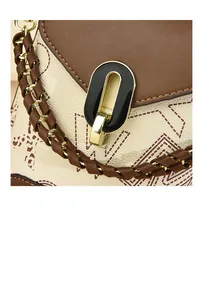 Gros plan du mini sac en cuir contrasté avec texture grainée et fermoir ovale en métal