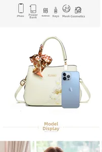 Detail view of cream handbag with floral embroidery, silk scarf, and size reference