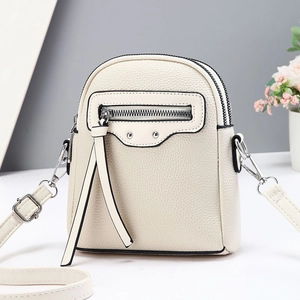 Sac bandoulière beige chic en cuir grainé avec pompons élégants pour femme moderne