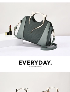 Detail of grey-green shell bag featuring unique cat-ear metal handles and woven texture