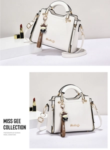 Detailed view of white lychee texture handbag with golden hardware and cartoon charm