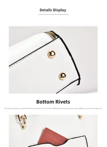 Detail of white leather handbag showing gold bottom rivets and functional card pocket