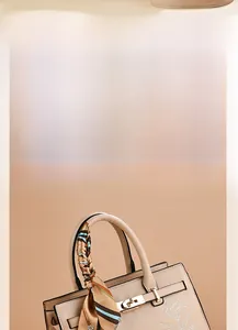 Detailed embroidery of white flowers and silk scarf handle on elegant beige handbag