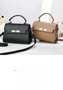Detail showing high-quality leather texture and metallic lock buckle of the handbag