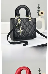 Detailed view of quilted black and red handbags with gold star pendant and slim strap