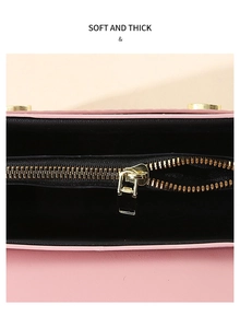 Detail view of pink leather bag interior with black lining and golden zipper pocket