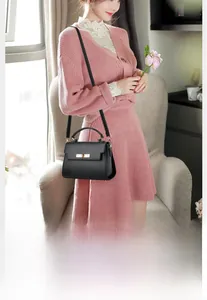 Detailed view of black lychee grain leather bag with gold hardware and rotary lock