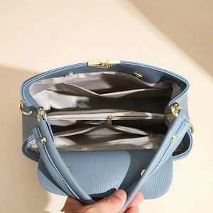 Interior view of leather handbag showing multiple compartments and herringbone lining