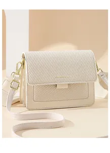 Detail of cream mini phone bag showing woven texture flap and gold metal hardware