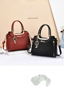 Detail of woven texture handbags in burgundy and black with pearl clover charms