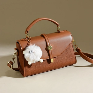 Elegante braune Handtasche mit Lychee-Textur und süßem Plüsch-Anhänger für Damen
