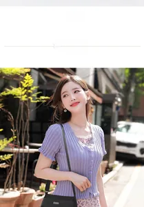 Small black nylon crossbody bag worn over a purple knit top and floral dress for daily use