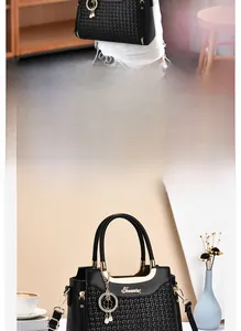 Detail of black woven handbag featuring clover pearl tassel and gold metal handle hardware