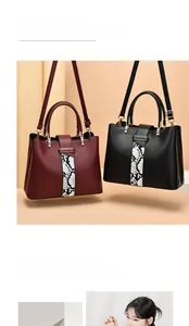 Detail of burgundy and black pebbled leather bags with snakeskin texture inlay and metal handles