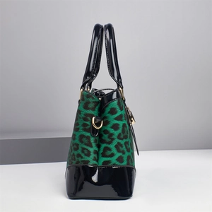 Detail view of green leopard print canvas tote with glossy black patent leather handles